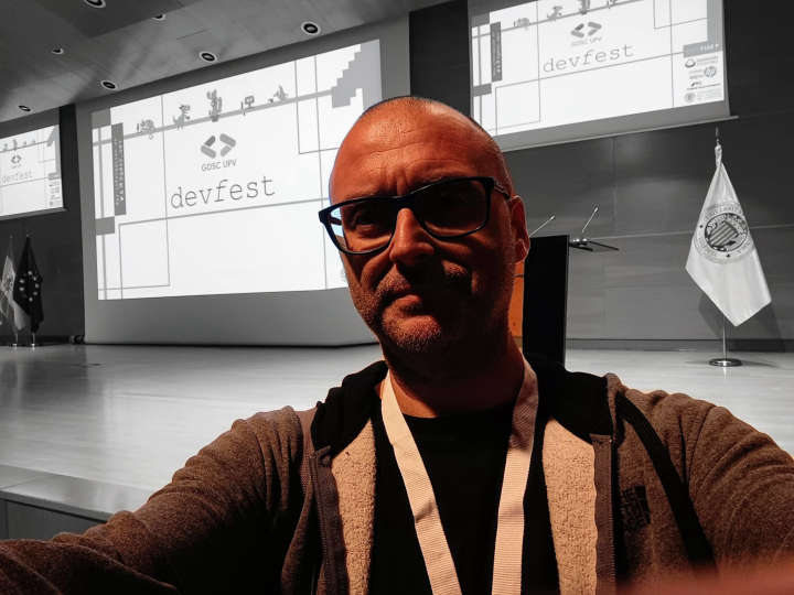 Selfie con el escenario del DevFest de la UPV de fondo.